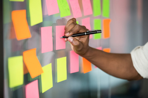 une personne écrit sur des post-it 