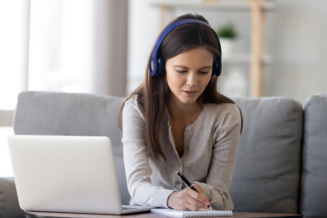 femme casque laptop prise de note traductrice